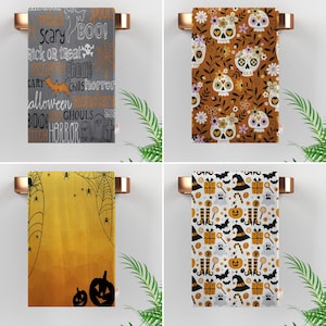 Op de afbeelding: Vier verschillende Halloween-themakookhanddoeken. De eerste handdoek is grijs met witte tekst die "Scary Boo!" "Trick or Treat" "Ghouls" "Chills Horror" "Halloween" "Monsters" "Boo!" "Ghouls" "Witch Horror" zegt. De tweede handdoek is oranje met witte bloemen en zwart-witte schedelontwerpen. De derde handdoek is geel met zwarte spinnenwebben en zwarte spinnen. De vierde handdoek is wit met zwarte en oranje Halloween-themaontwerpen, waaronder vleermuizen, geesten, snoepstokken, pompoenen en heksenhoeden.