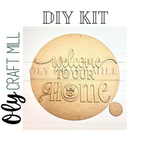 May include: DIY craft kit for a welcome home sign. The kit includes a round wooden sign with the words "Welcome to our home" and a smaller circle for the center of the sign.