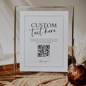 May include: A framed sign with the words "CUSTOM text here" in elegant script. Below the text is a QR code and the words "Please scan the QR code if you your text here your text here your text here". The sign is in a gold frame.