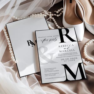 May include: Elegant wedding invitation suite featuring white high heels, pearl necklaces, and a ring. The invitation cards have black text on a white background, with the names Rebecca and Marcell, and the date 10.10.2026.