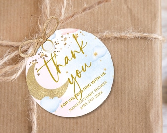 May include: Round thank you tag with a blue and pink watercolor background featuring a gold glitter crescent moon, stars, and clouds. The text "Thank you" is written in gold script. The tag also includes the text "For celebrating with us Nahleigh's Baby Shower April 31st 20XX".