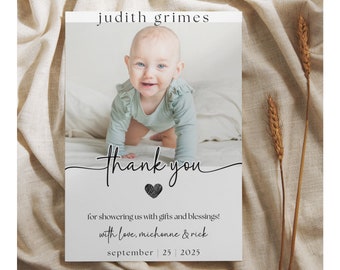 May include: A thank you card with a photo of a baby in a light blue onesie. The card says "thank you" with a heart and "for showering us with gifts and blessings! with love, michonne & rick september | 25 | 2025".