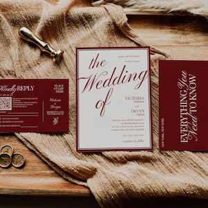 May include: A wedding invitation suite featuring a burgundy and cream color scheme. The suite includes an invitation, RSVP card, and details card. Gold wax seals and a gold pen are also present on a wooden tray.