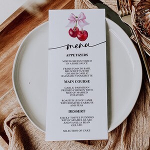 Könnte beinhalten: Eine weiße Speisekarte mit einer Kirschillustration und dem Wort "Menu" in schwarzer Schrift. Die Speisekarte listet Vorspeisen, Hauptgerichte und Desserts auf. Zu den Vorspeisen gehören gemischter Salat, der in einer Rosensoße mariniert ist, und frische Tomaten-Basilikum-Bruschetta mit zerdrücktem Knoblauch. Die Hauptgerichte sind Knoblauch-Parmesan-gepresstes Hähnchen mit einem Beilagen von Kartoffelpüree und gebratenes Lammkeule mit gerösteten Karotten und Erbsen. Zu den Desserts gehören klebriger Toffee-Pudding mit Karamellglasur und Vanille-Bohnen-Eis sowie eine Auswahl an Kuchen.