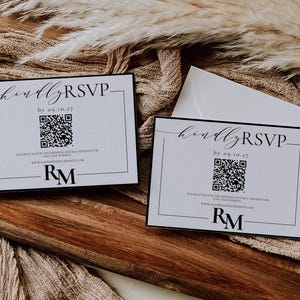 Op de afbeelding: Twee witte RSVP-kaarten met zwarte randen en tekst. De tekst luidt "kindly RSVP by 09.10.27". Elke kaart heeft een zwart-witte QR-code en de initialen "RM" in zwart.