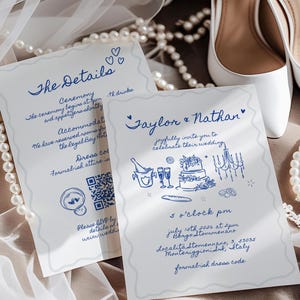 May include: Wedding invitation cards with blue handwritten text and illustrations, including the names "Taylor & Nathan". The cards are on a soft surface with white bridal shoes and pearl necklaces.