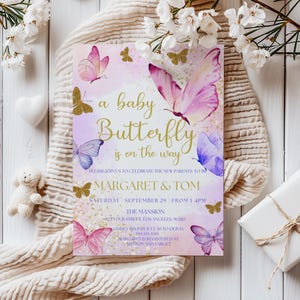 May include: A baby shower invitation with a pink and purple watercolor butterfly design. The text reads "a baby butterfly is on the way" and includes the names "Margaret & Tom" and the date "Saturday, September 29".