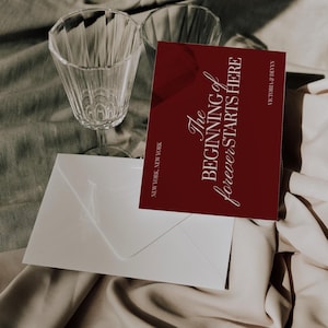 May include: A burgundy invitation card with the text "The Beginning of forever STARTS HERE" and the names Victoria & Devyn. A white envelope and two clear wine glasses are also in the image. The text "NEW YORK, NEW YORK" is at the bottom.