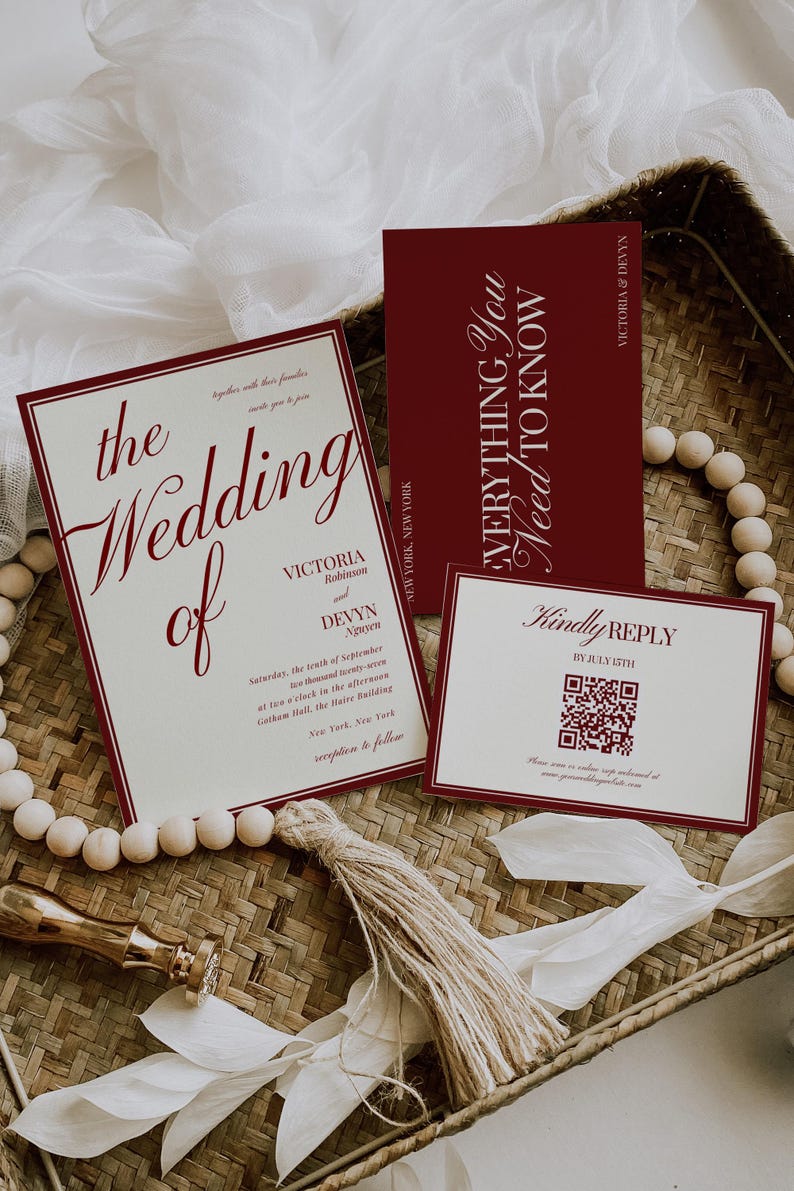 May include: Wedding invitation suite with burgundy text on cream-colored cards. The main invitation reads "the Wedding of Victoria Robinson and Devyn Nguyen." Includes a reply card with a QR code and a card that says "Everything You Need To Know."
