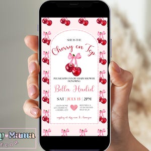 Puede incluir: Una invitación de baby shower rosa y blanca con un tema de cereza. La invitación dice "Ella es la cereza del pastel" y presenta un lazo rosa y cerezas. La invitación es para Bella Hadid y está programada para el sábado 15 de julio a las 2 PM.