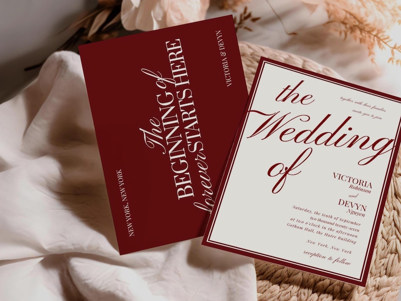 May include: Two wedding invitation cards. One card is burgundy with the text "The Beginning of Forever Starts Here" in white script. The other card is off-white with burgundy text that reads "The Wedding of Victoria and Devyn".
