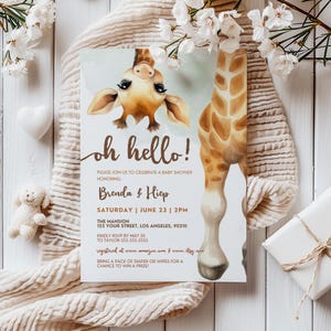 Puede incluir: Una invitación a un baby shower con una ilustración de jirafa y la frase "oh hello!". La invitación incluye la fecha, hora, lugar y detalles de RSVP. El diseño incorpora elementos florales. El evento es para Brenda & Hiep.