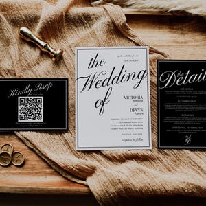 May include: Wedding invitation suite with a gold wax seal and a gold-colored stamp. The suite includes a black RSVP card with a QR code, a white invitation, and a black details card. The invitation is for Victoria and Devyn.
