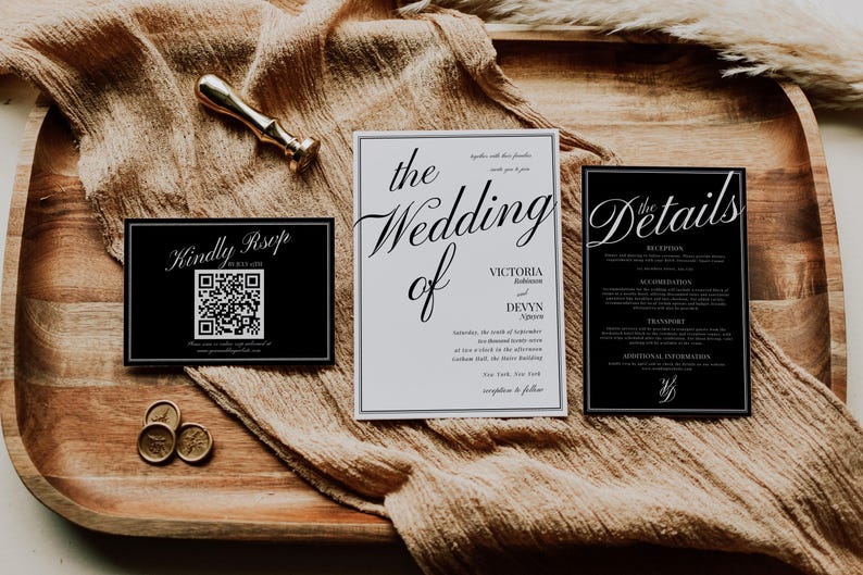 May include: Wedding invitation suite with a gold wax seal and a gold-colored stamp. The suite includes a black RSVP card with a QR code, a white invitation, and a black details card. The invitation is for Victoria and Devyn.