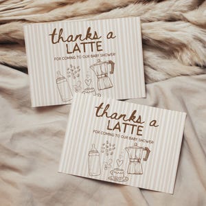 May include: Two baby shower thank you cards with a striped background. The cards read "thanks a LATTE FOR COMING TO OUR BABY SHOWER!" and feature illustrations of a baby bottle, coffee beans, a coffee maker, and a coffee cup.