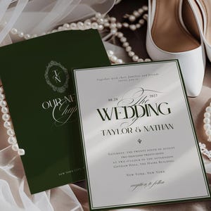 Może przedstawiać: Zaproszenie ślubne z napisem "The Wedding Taylor & Nathan" w kolorze ciemnozielonym i białym. Zaproszenie znajduje się obok ciemnozielonej broszury z napisem "Our New Chapter". Białe buty ślubne i naszyjniki z pereł r&oacute;wnież na zdjęciu.