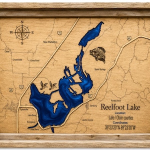 Könnte beinhalten: Eine gerahmte hölzerne bathymetrische Karte des Reelfoot Lake mit einer tiefblauen Wassereinlage, eingravierten Straßen und Orientierungspunkten. Die Karte enthält eine Windrose, Illustrationen von zwei Enten und einem Fisch sowie Text.