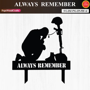 May include: Black silhouette of a soldier kneeling in prayer with a rifle and helmet on the ground. The text "ALWAYS REMEMBER" is written on a plaque below the soldier.