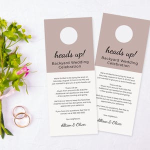 May include: Two door hanger wedding invitations with a taupe header and a white body. The text reads "heads up! Backyard Wedding Celebration." A bouquet of pink roses and gold wedding rings are also in the image.