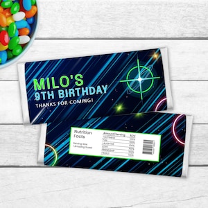 Op de afbeelding: Een blauwe en groene chocoladebar-verpakking met een galaxie-thema met de tekst "MILO'S 9TH BIRTHDAY THANKS FOR COMING!" en een voedingswaarde-etiket waarop geluk, lachen, liefde, vriendschap en familie worden vermeld als 100% van de dagelijkse waarde.