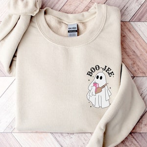 May include: A beige sweatshirt with a ghost graphic and the text 'BOO-JEE'.