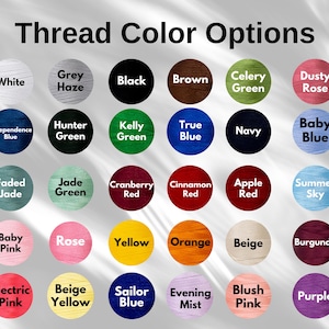 May include: Image displaying a color chart labeled "Thread Color Options." The chart features a variety of thread colors, each presented in a circular format. Colors include white, grey, black, brown, green, and various shades of red, blue, pink, and yellow.
