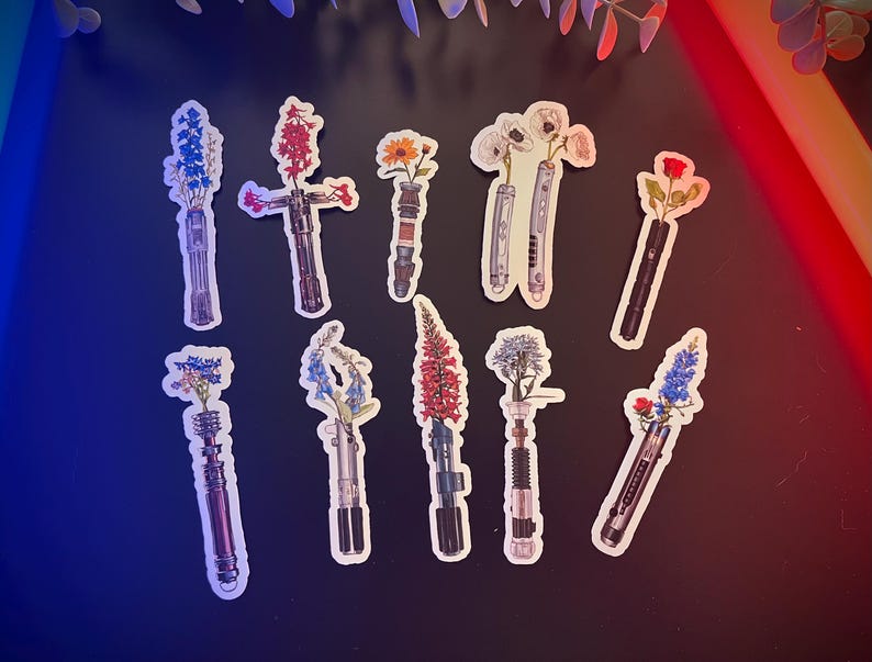 May include: Ten colourful floral lightsaber stickers with different flower arrangements. The stickers are on a blue and red background.