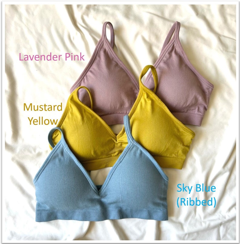 May include: Three seamless bras in different colors: lavender pink, mustard yellow, and sky blue (ribbed).