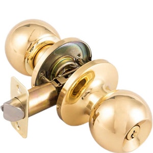 May include: A gold door knob with a round handle and a keyhole. The knob is made of metal and has a polished finish.