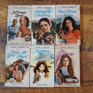 May include: Six vintage romance novels are displayed, each with a different cover illustration. The titles include "In Comes Love," "Greengold Autumn," and "One More River." The authors' names are also visible on the covers.