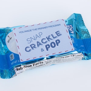 Puede incluir: Una bolsa de aperitivos azul y blanca con una etiqueta blanca que dice "You made the primary program Snap Crackle & Pop".