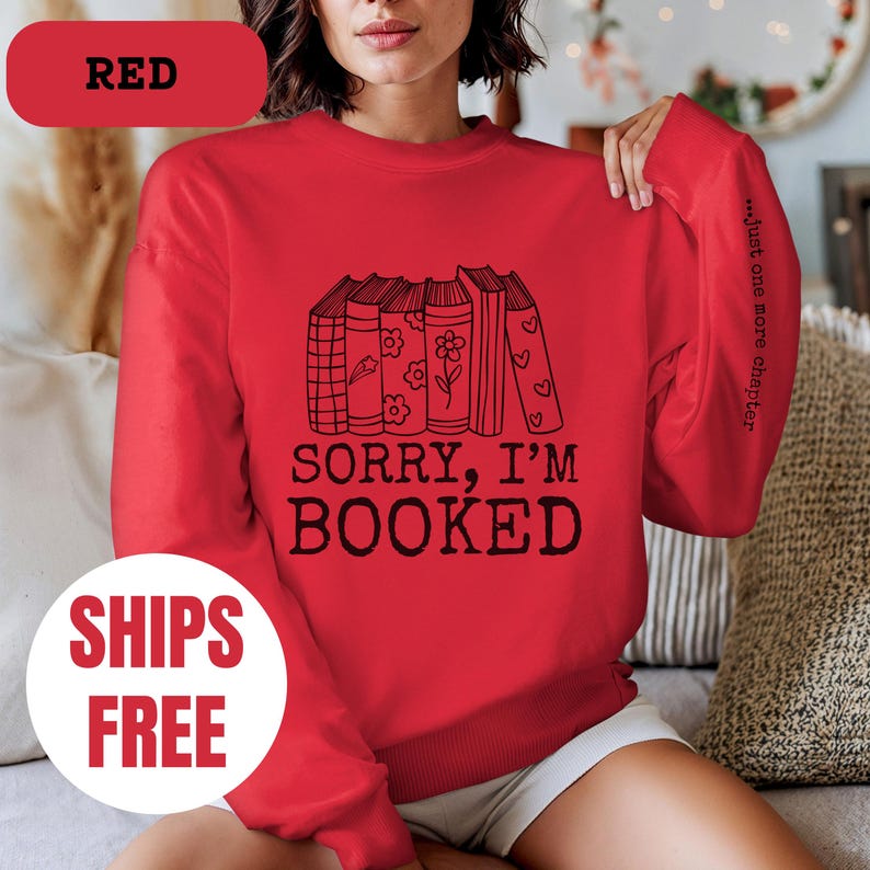 May include: Red sweatshirt with a stack of books and the text "Sorry, I'm Booked" and "...just one more chapter" on the sleeve.
