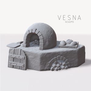 Puede incluir: Un horno de panadería en miniatura gris con techo abovedado, entrada arqueada y una pequeña puerta de madera. El horno tiene una plataforma con tres panes y el texto "VESNA SCULPTS". Una pala descansa a un lado.