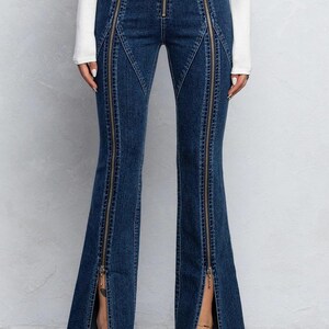 Pu&ograve; includere: Jeans in denim blu con pi&ugrave; dettagli di cerniera sulle gambe. I jeans hanno uno stile a gamba svasata.