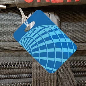 May include: Black luggage bag with a red "CREW" strap and a blue luggage tag with a globe design.