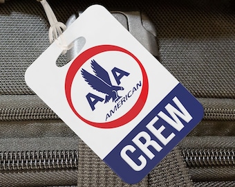 May include: A black travel bag with multiple zippered compartments and a handle marked with the word "CREW" in red. An "American Airlines" tag is attached, featuring a logo with a stylized eagle.