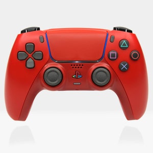 May include: A red PlayStation 5 DualSense wireless controller with black buttons and a blue light bar. The controller has a PlayStation logo on the front.