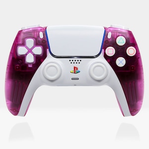May include: A white and pink PlayStation 5 DualSense wireless controller. The controller has a white faceplate with the PlayStation logo and a pink translucent shell.