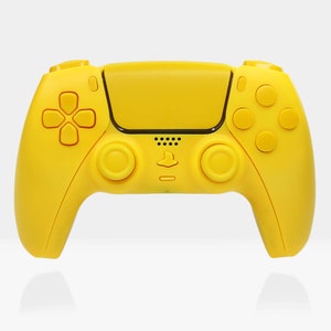Puede incluir: Un mando inalámbrico PlayStation 5 DualSense de color amarillo brillante con detalles negros. El mando tiene un panel táctil, botones y sticks analógicos.