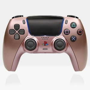 Könnte beinhalten: Ein roségoldener PlayStation 5 DualSense Wireless-Controller mit schwarzen Tasten und einem PlayStation-Logo. Der Controller hat einen strukturierten Griff und ein elegantes Design.