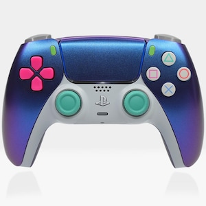 Puede incluir: Un mando de PlayStation 5 azul y morado con botones de color turquesa y rosa. El mando tiene una placa frontal blanca con el logotipo de PlayStation.