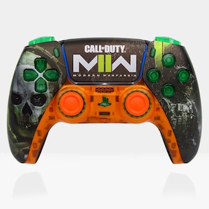 May include: Orange and black PlayStation 5 controller with a Call of Duty: Modern Warfare II design. The controller has a skull graphic on the left side and the game's logo on the right side.