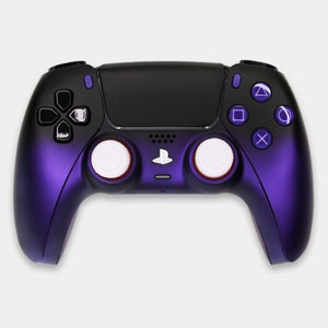 Könnte beinhalten: Ein schwarz-violetter Gamecontroller mit weißen Thumbsticks und violetten Aktionstasten. Der Controller hat ein PlayStation-Logo und ein mattes Finish. Das Design ist schlank und modern, geeignet für Spiele.