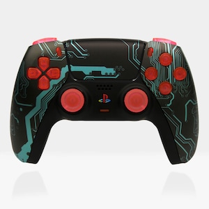 May include: A black PlayStation 5 DualSense controller with a blue and green circuit board design. The controller has red buttons and red analog sticks.