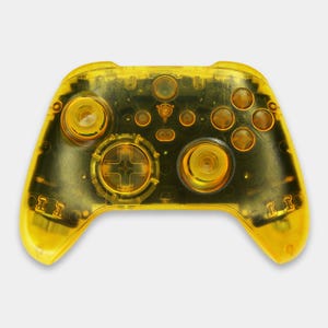 May include: A transparent yellow video game controller with black internal components. The controller features a directional pad, buttons, and analog sticks. The design is a vibrant yellow, with a clear plastic shell.