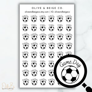 May include: A sheet of black and white soccer-themed stickers. The stickers feature a soccer ball with different text around it, including "Game Day", "Practice", "Home Game", and "Away Game".