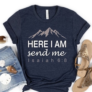 May include: A navy blue t-shirt with a white graphic of mountains and the text "HERE I AM send me Isaiah 6:8".