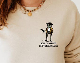 Hold On Partner Im Overstimulated Pocket Sweatshirt, Sarcastic Mental Health Frog Minimalist Sweatshirt, Cowboy Frog Introvert Sweatshirt
