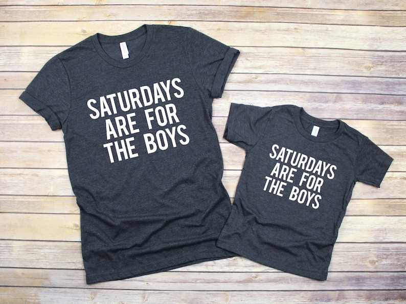 Peut inclure: Deux t-shirts gris avec le texte "Saturdays are for the boys" imprim&eacute; en blanc.