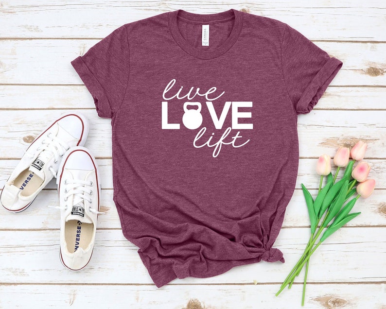 May include: A maroon t-shirt with the text "live LOVE lift" in white lettering. A white kettlebell icon is centered in the word "LOVE".